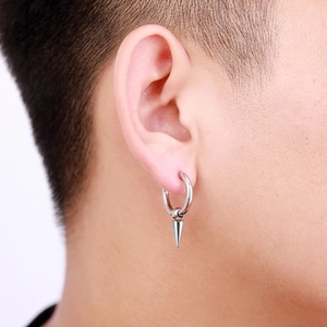 Detail of high-polished stainless steel huggie hoop earrings with punk spike pendant