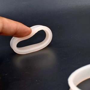 Close-up of soft translucent white silicone ear gauges showing high flexibility and elasticity