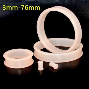 Macro detail of oversized flexible silicone double flared ear gauges and flesh tunnels