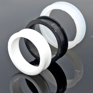 Detail view of black, white and clear flexible silicone double flared ear plugs gauges