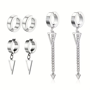 Détail de trois paires de boucles d'oreilles clips en acier argenté avec pendentifs triangle