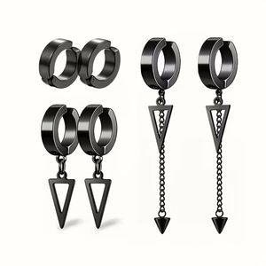 Détail de boucles d'oreilles en acier noir avec pendentifs triangles et pompons chaînes