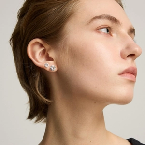 Gros plan de deux boucles d'oreilles en zircone avec sertissage à 4 griffes sur l'oreille