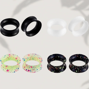 Detail of colorful double flared silicone ear tunnels in black white and spotted patterns