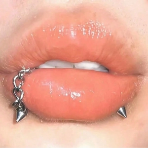 Silver 16G stainless steel lip ring with chain and spike accents for punk style piercing