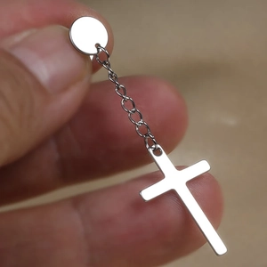 Dettaglio di orecchino a croce in argento con catena lunga e perno per uomini