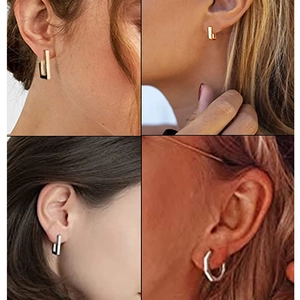 Vue détaillée de boucles d'oreilles géométriques en acier titane sur l'oreille d'un mannequin