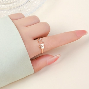 Anello in oro rosa con farfalla, cuore lettera A e zirconi mostrato sulla mano