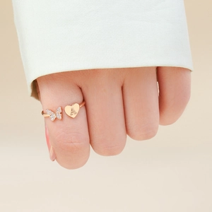 Dettaglio dell'anello a farfalla cuore in oro rosa con zirconi e incisione lettera A
