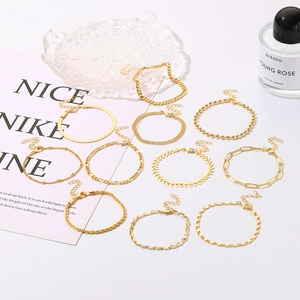 Detail eines 10-teiligen goldenen minimalistischen Armbandsets mit verschiedenen Ketten