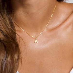 Close-up of minimalist gold-plated letter A pendant necklace on a female model