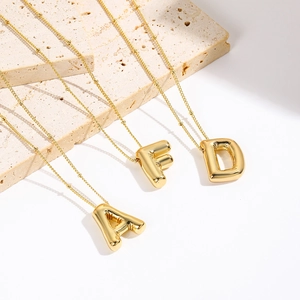 Detail of gold-plated puffy balloon A F D initial pendants with beaded chain necklaces