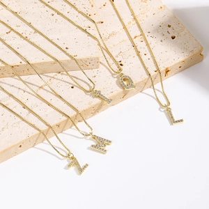 Detail shot of gold-plated initial pendants with sparkling cubic zirconia on box chains