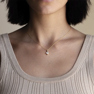 Close-up of minimalist gold zircon necklace with a square cut pendant on a model