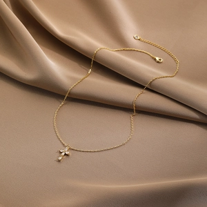 Close-up of gold-plated cross pendant with marquise zircons on a luxury silk background