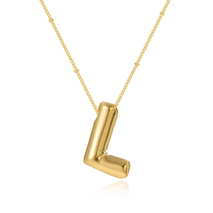 Macro detail of polished gold bubble letter L pendant on a delicate satellite chain necklace