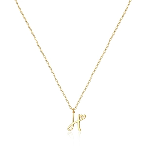 Dettaglio macro della collana con ciondolo a lettera H dorata e piccolo cuore traforato