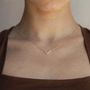 Detailed view of a minimalist gold V-shaped necklace with shimmering pavé zircon stones