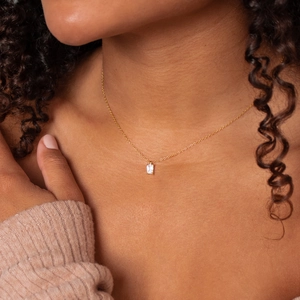 Gros plan détaillé d'une chaîne en or 18K avec un pendentif en zircon rectangulaire chic