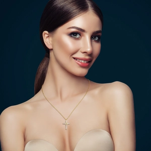 Exquisite gold-plated copper cross pendant necklace with round zircons on a model