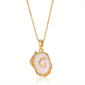 Detailopname van de vintage gouden letter G hanger met roze emaille aan een ketting
