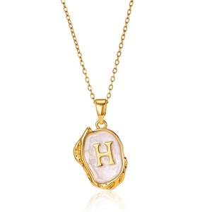 Detailopname van de vintage gouden H-letter hanger met luxe parelmoer inlegwerk