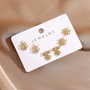 Detailed close-up of 16K gold plated stud earrings set with crystal leaf and bow shapes