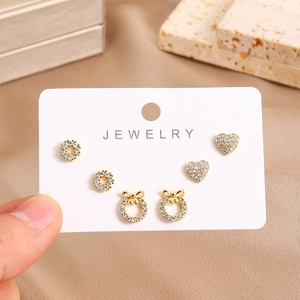 Close-up of three pairs of 16K gold plated stud earrings with zircons on display card