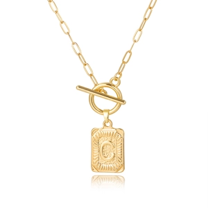 Macro-detail van de gouden paperclip ketting en rechthoekige hanger met de letter C