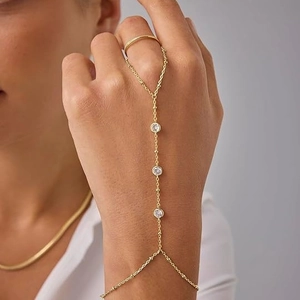 Elegante gouden vingerring armband met drie heldere zirkonen en fijne kralenketting