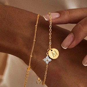Details des goldene Gliederkette mit M-Initialen-Anhänger und Kristall-Kleeblatt