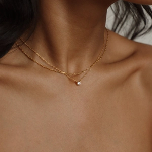 Dettaglio della collana dorata a due strati con catena a corda e pendente in zircone