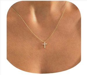 Close-up of a minimalist 18k gold-plated cross pendant necklace with sparkling pavé crystals