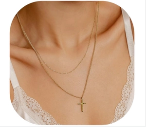 Close-up of elegant double-layered gold cross necklace worn by model with lace clothing