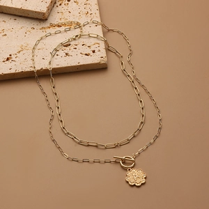 Double-layer gold clover necklace with initial A pendant and toggle clasp on stone
