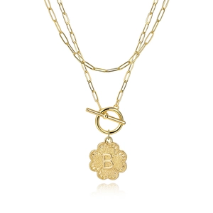Detail of gold double layer necklace with paperclip chain, OT toggle clasp and letter B pendant