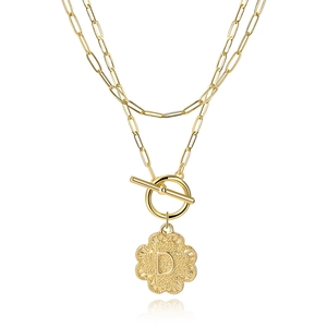Macro detail of gold double-layer paperclip chain necklace with letter D clover pendant