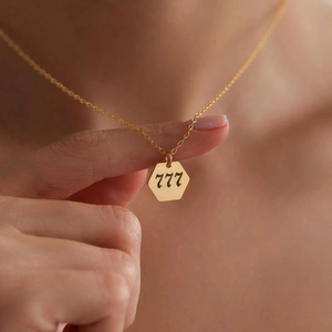 Gold angel number 777 necklace with hexagonal pendant for women on model neck