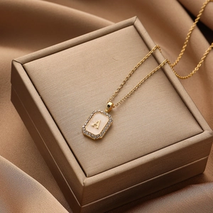 Detailed macro view of gold letter A pendant with shell inlay and micro-pave zircons