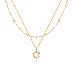 Dettaglio della collana dorata a due strati con ciondoli stella luna e zirconi chiari