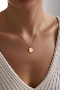 Detail of angel number 777 hexagonal gold pendant necklace worn on a model