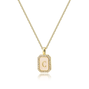 Close-up of golden square pendant with letter C and shell inlay surrounded by zircon