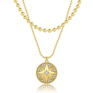 Dettaglio collana dorata a due strati con catena a sfere e ciondolo a stella con zirconi