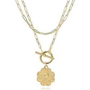 Detail of double-layer gold chain necklace with flower pendant featuring letter P and OT clasp