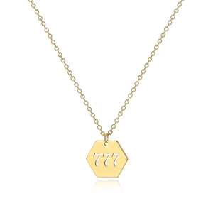 Macro detail of gold-plated lucky number 777 pendant on a delicate cable chain necklace