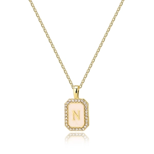 Close-up of gold square necklace with pink shell and letter N inlaid with zircons