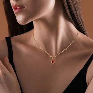 Elegante Goldkette mit rechteckigem tiefrotem Geburtsstein-Anhänger an einem Model