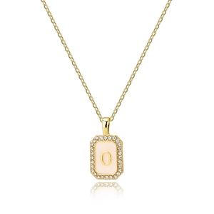 Macro detail of golden octagonal pendant with white shell inlay and zircon letter O