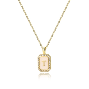 Macro view of gold initial T pendant with zircon border and shell enamel background