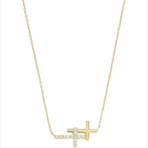 Detailed close-up of double cross pendants with sparkling white zircons on a gold chain
